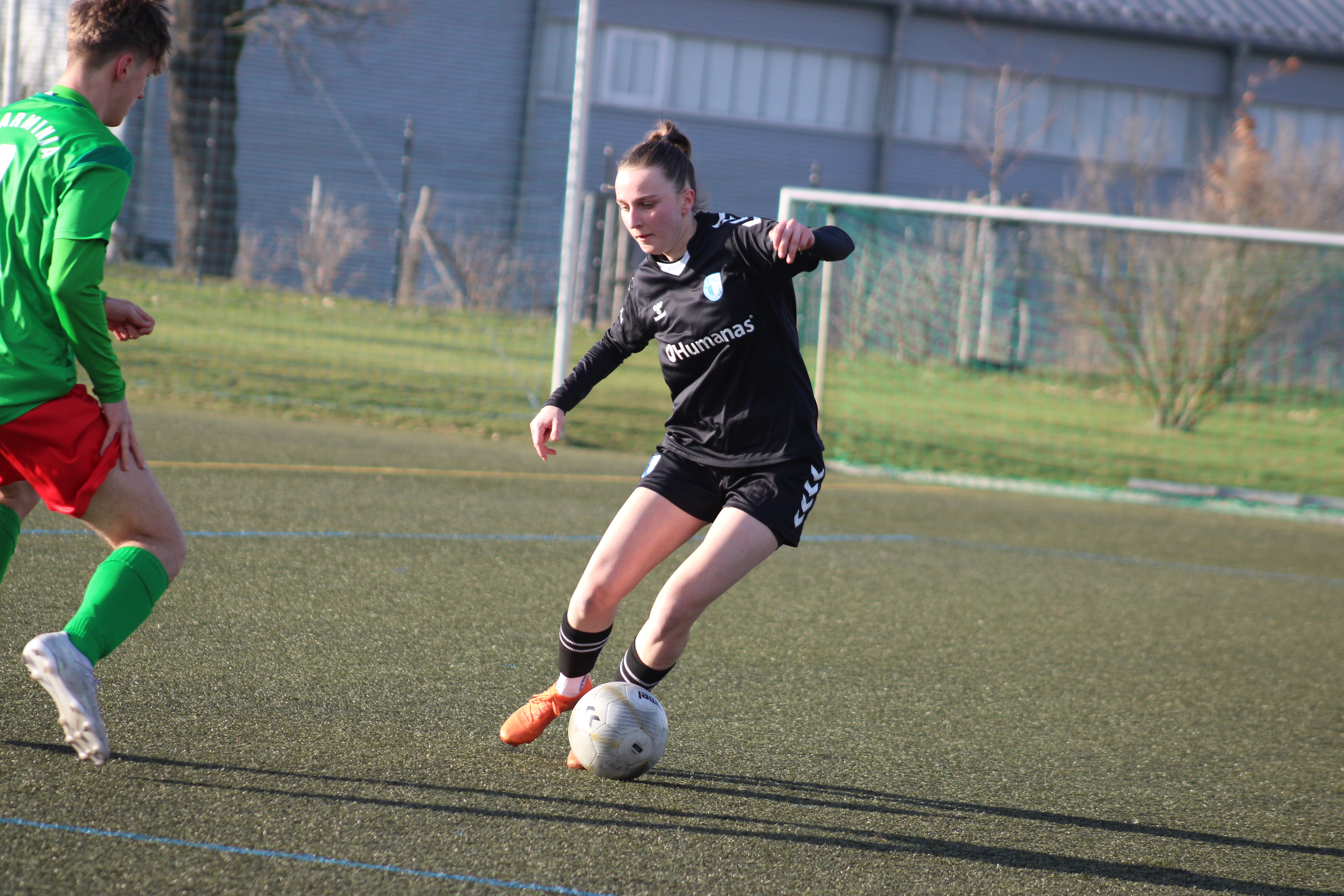 Beine einer Fußballerin beim schießen eines Fußballs